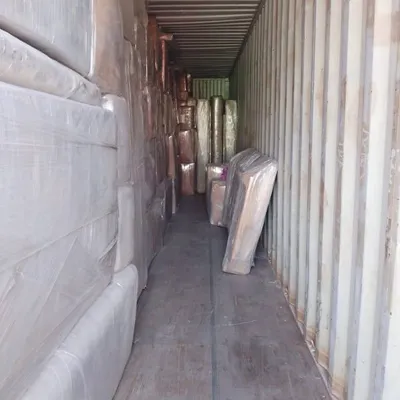 Inside a tightly packed container, cargo wrapped and stacked floor to ceiling